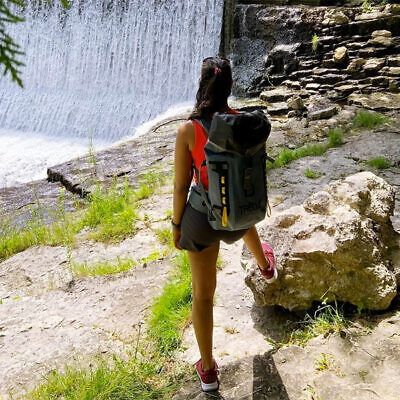 Woman wearing waterproof backpack at waterfall
